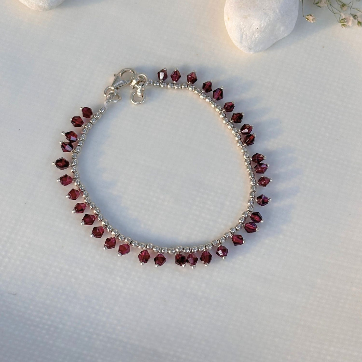 Garnet silver 925 bracelet for women
Natural garnet gemstone silver bracelet
Red garnet 925 sterling silver bracelet
Silver bracelet with red gemstones on a textured white surface