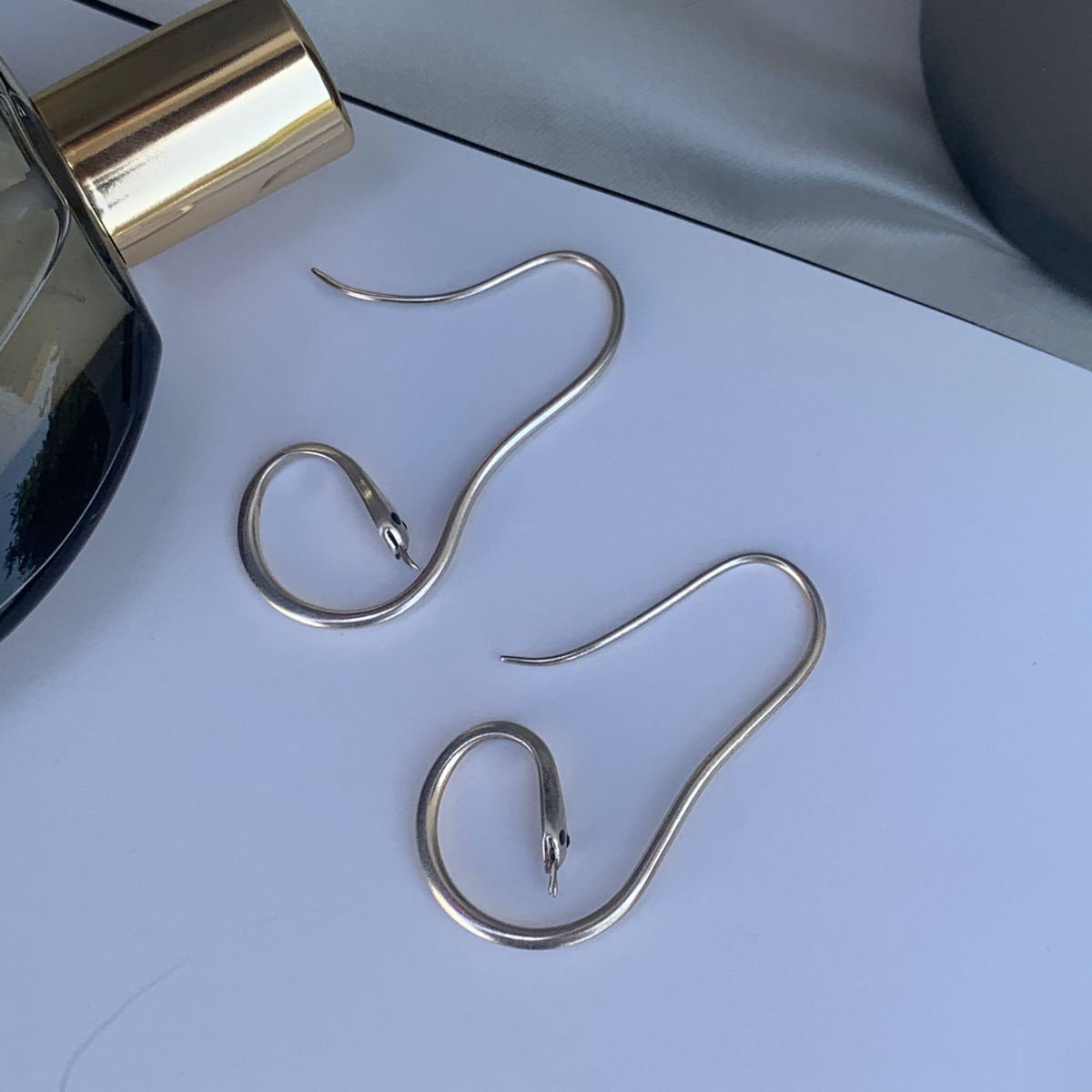 Pair of 925 silver curved snake earrings with stone eyes