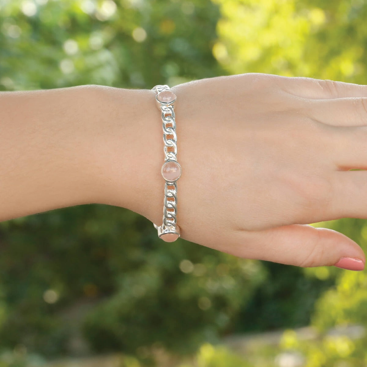 Model wearing rose quartz cabochon bezel-set sterling silver curb chain bangle