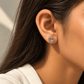 Model wearing 925 sterling silver tanzanite open heart stud earrings