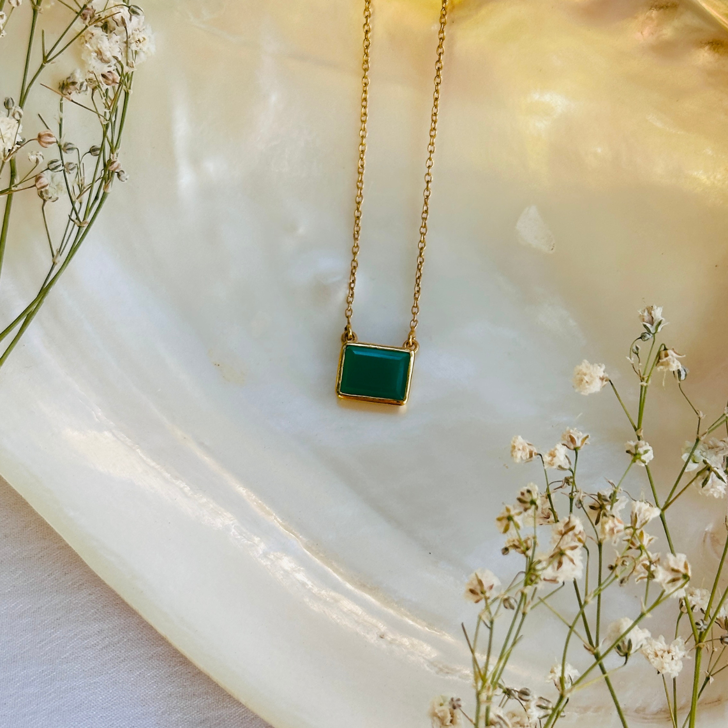 Natural green onyx gemstone silver necklace

Green onyx 925 sterling silver pendant

Green onyx stone silver necklace India

Elegant green onyx silver necklace online

Minimal green pendant 

minimal pendant 

minimal jewelry 

Person wearing a gold necklace with a green pendant


Gold necklace with a green pendant on a white stone surface with white flowers.