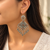 Model wearing oxidised 925 silver coral diamond-shaped drop earrings