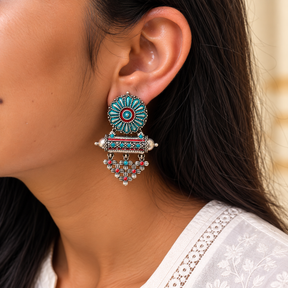 Model wearing oxidised 925 silver teal enamel lattice drop earrings