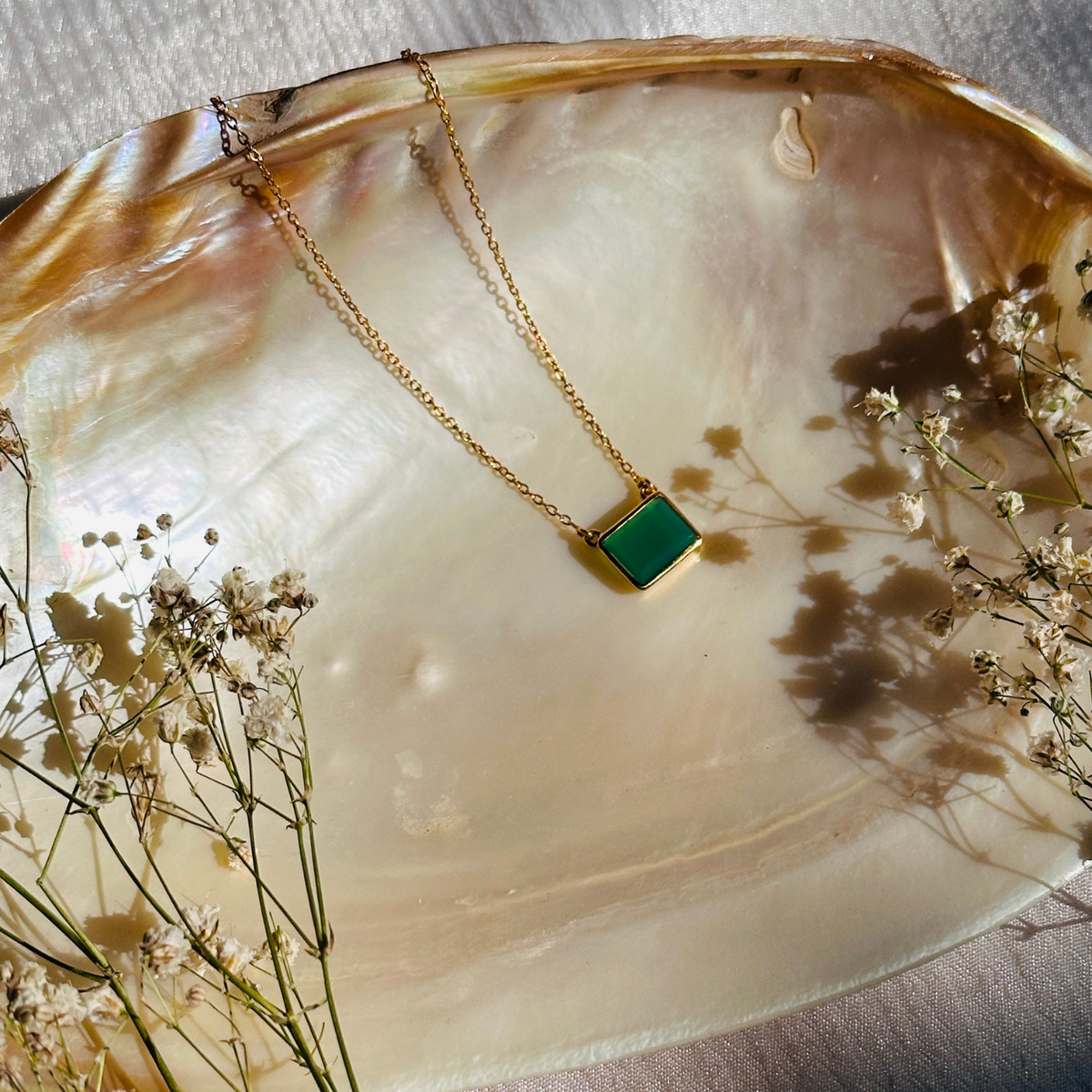 Green onyx silver 925 pendant necklace

Natural green onyx gemstone silver necklace

Green onyx 925 sterling silver pendant

Green onyx stone silver necklace India

Elegant green onyx silver necklace online

Minimal green pendant 

minimal pendant 

minimal jewelry 



Gold necklace with a green pendant on a large shell with dried flowers.