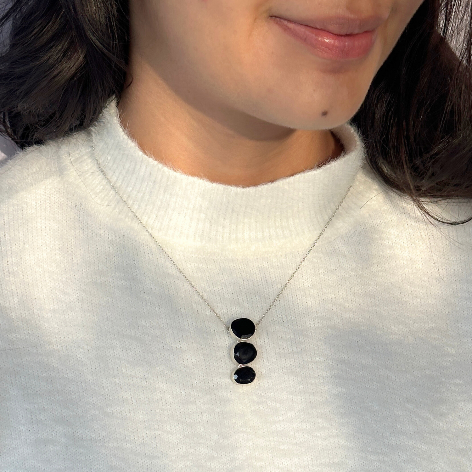 Natural black onyx gemstone silver necklace

Black onyx 925 sterling silver pendant

Black onyx stone silver necklace India

Elegant black onyx silver necklace online

Minimal pendant 

Minimal necklace for daily wear 


Person wearing a white sweater with a necklace featuring three black stones.