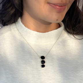 Natural black onyx gemstone silver necklace

Black onyx 925 sterling silver pendant

Black onyx stone silver necklace India

Elegant black onyx silver necklace online

Minimal pendant 

Minimal necklace for daily wear 


Person wearing a white sweater with a necklace featuring three black stones.